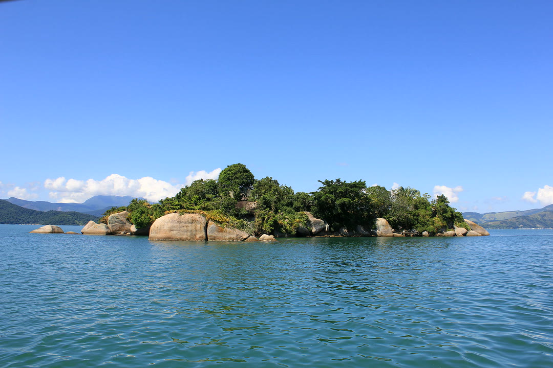 Ilha com pedras e mata na baía de Paraty